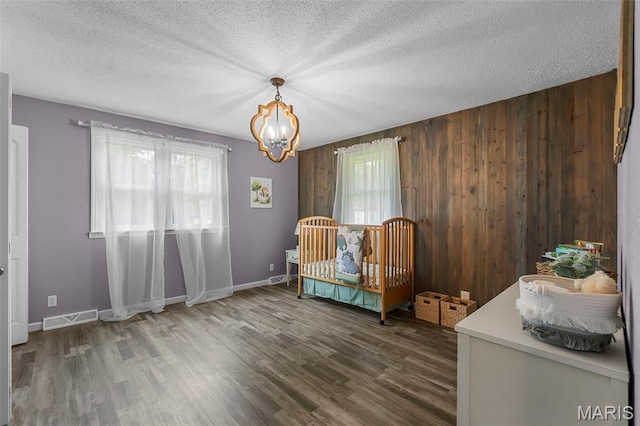 70 Garnet Ln, Cape Girardeau, MO 63701 - bedroom with a chandelier, wood finished floors, a textured ceiling, and wooden walls