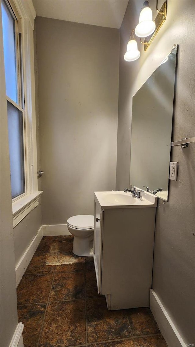 1412 Benton St, Saint Louis, MO 63106 - half bathroom with stone tile flooring, baseboards, toilet, and vanity