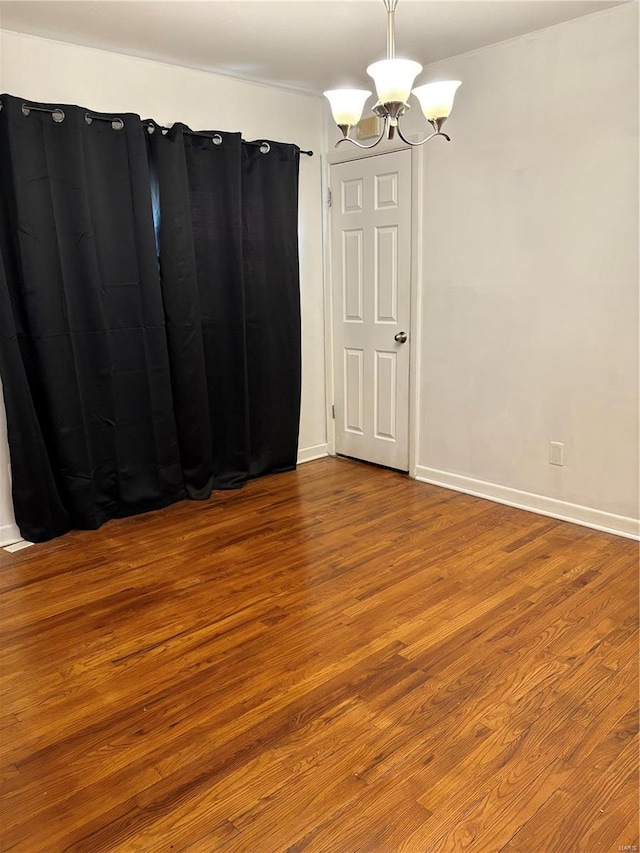10356 Saint Matthew Ln, Saint Ann, MO 63074 - unfurnished room featuring a chandelier, wood finished floors, and baseboards