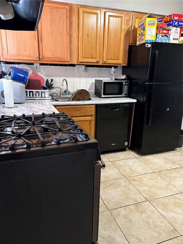 10356 Saint Matthew Ln, Saint Ann, MO 63074 - kitchen featuring black appliances, range hood, light countertops, and decorative backsplash