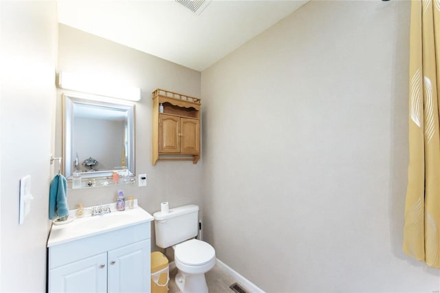 half bath with toilet, vanity, and baseboards