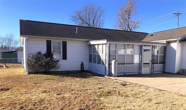 view of front facade with a sunroom and roof with shingles