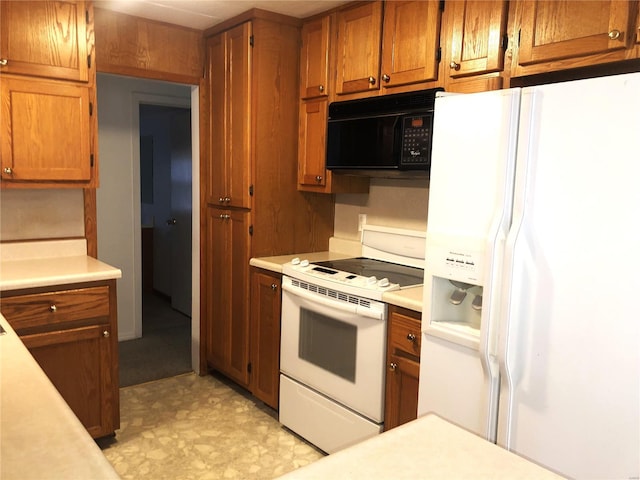 kitchen featuring white appliances, brown cabinets, light countertops, and light floors
