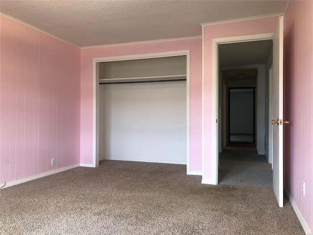 unfurnished bedroom featuring carpet flooring, ornamental molding, a closet, baseboards, and a textured ceiling