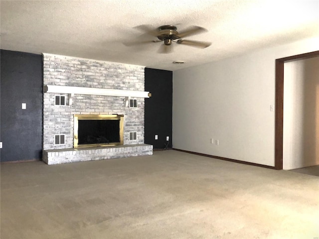 unfurnished living room with a ceiling fan, carpet floors, a brick fireplace, and a textured ceiling