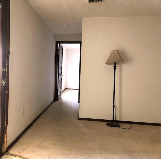 hallway with carpet floors and baseboards