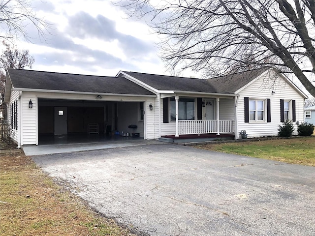 ranch-style home with covered porch, driveway, an attached garage, and roof with shingles