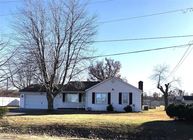 view of front of property featuring a chimney, an attached garage, a front yard, central AC, and driveway
