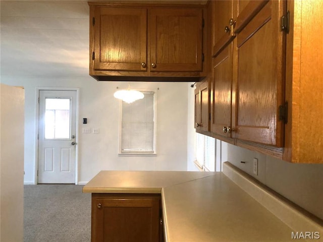 1210 N Prairie, Bloomfield, MO 63825 - kitchen featuring brown cabinets, carpet flooring, light countertops, a peninsula, and baseboards