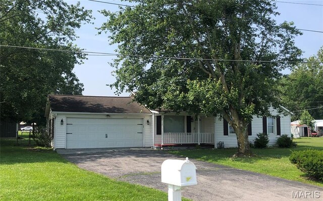 1210 N Prairie, Bloomfield, MO 63825 - view of front facade with covered porch, driveway, a front lawn, and a garage