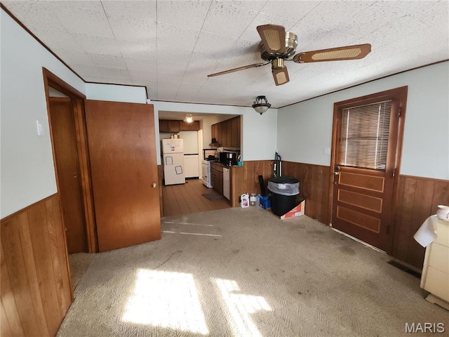 1238 Hoyt Dr, Saint Louis, MO 63137 - carpeted living room with wainscoting, wood walls, and a ceiling fan