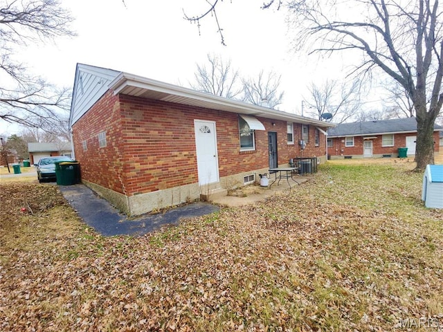 9409 Aetna Dr, Saint Louis, MO 63137 - back of house with brick siding, entry steps, and central AC unit