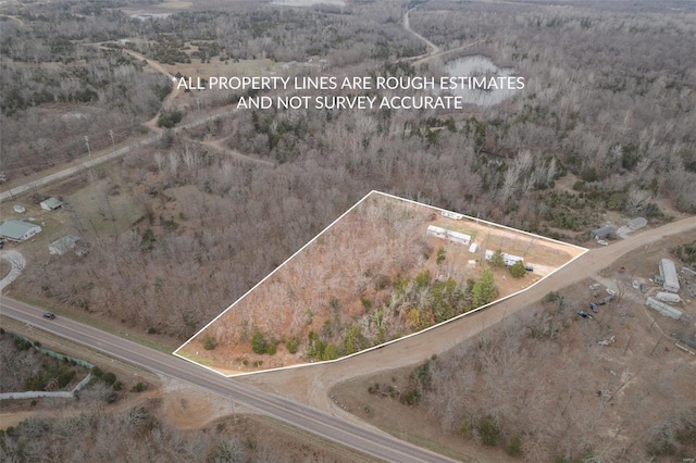 aerial overview of property's location with property parcel outlined and a heavily wooded area
