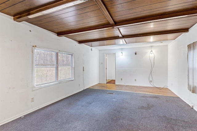 empty room with carpet, wooden ceiling, beamed ceiling, and baseboards