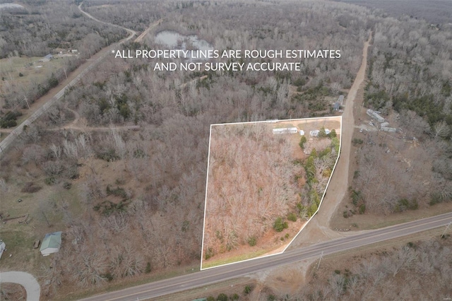 aerial overview of property's location featuring property parcel outlined and a heavily wooded area