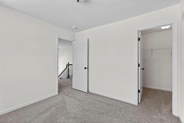 614 Tull Ct, Wentzville, MO 63385 - unfurnished bedroom with carpet, a walk in closet, baseboards, and a closet