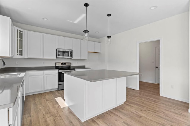 614 Tull Ct, Wentzville, MO 63385 - kitchen featuring appliances with stainless steel finishes, a sink, light wood-type flooring, white cabinets, and glass insert cabinets