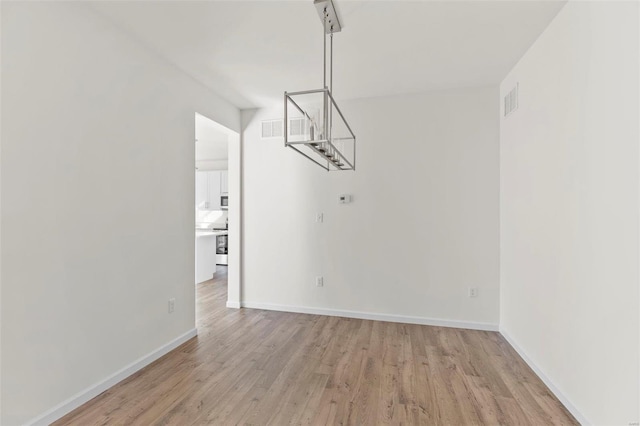 409 Fleming Cir, Wentzville, MO 63385 - unfurnished dining area with light wood-style flooring and baseboards