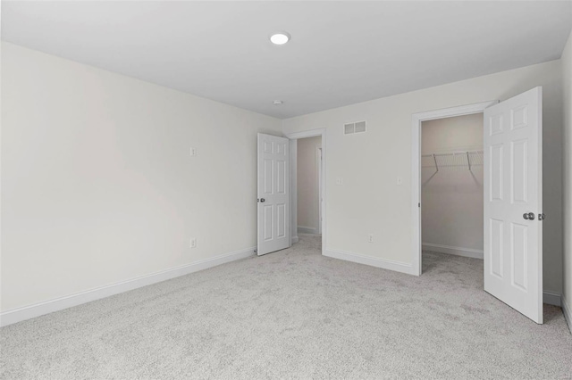 409 Fleming Cir, Wentzville, MO 63385 - unfurnished bedroom with light colored carpet, a walk in closet, baseboards, and a closet