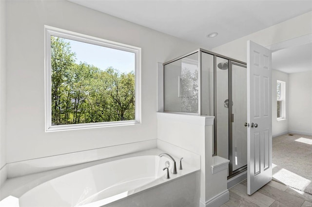 409 Fleming Cir, Wentzville, MO 63385 - full bath featuring a garden tub, a shower stall, and baseboards