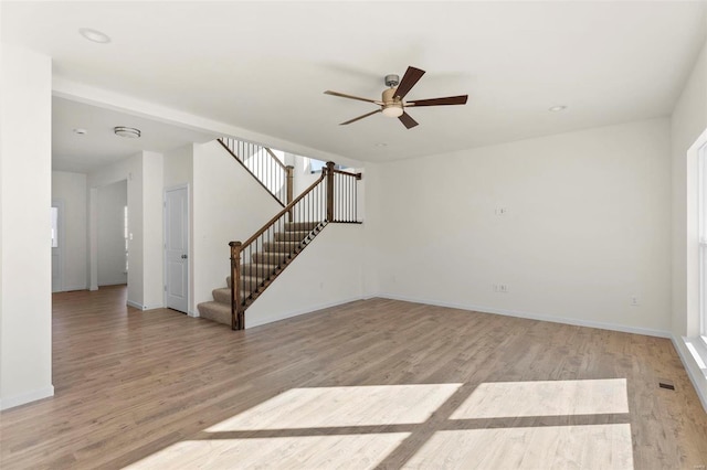 409 Fleming Cir, Wentzville, MO 63385 - unfurnished living room featuring ceiling fan, light wood-style floors, stairway, and baseboards