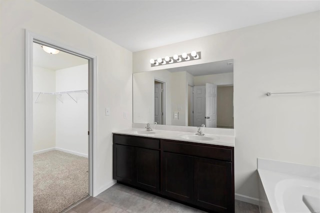 411 Fleming Cir, Wentzville, MO 63385 - bathroom with a spacious closet, double vanity, baseboards, and a bathtub