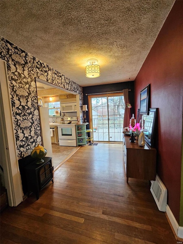3506 Ohio St, Alton, IL 62002 - corridor with wood-type flooring, wallpapered walls, a textured ceiling, and baseboards