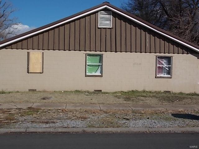 403 E 15th, Caruthersville, MO 63830 - view of property exterior featuring board and batten siding and concrete block siding
