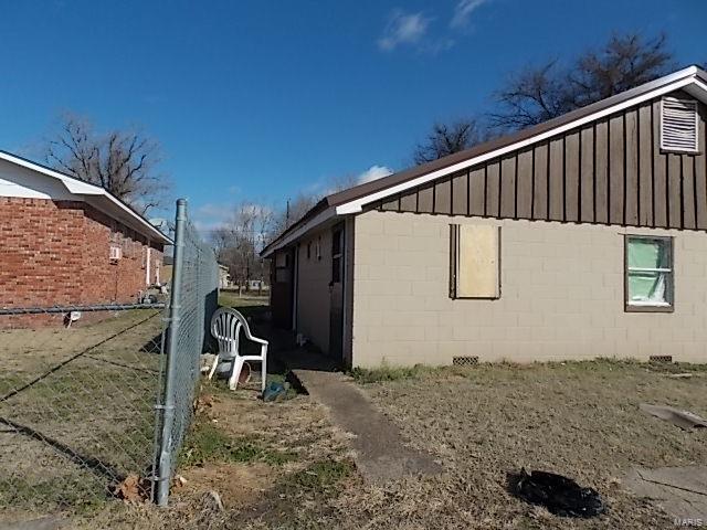 403 E 15th, Caruthersville, MO 63830 - view of side of property with board and batten siding and concrete block siding