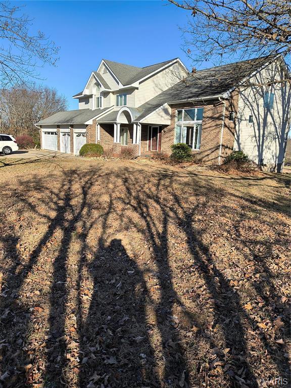 10740 Wilmena Ln, Rolla, MO 65401 - view of front of property featuring a garage, covered porch, driveway, and brick siding