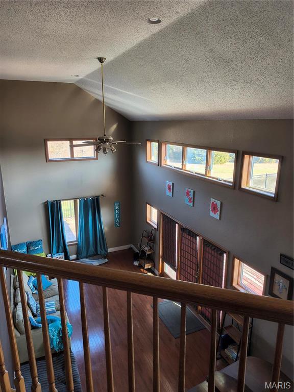 10740 Wilmena Ln, Rolla, MO 65401 - stairway with lofted ceiling, ceiling fan, a textured ceiling, wood finished floors, and baseboards