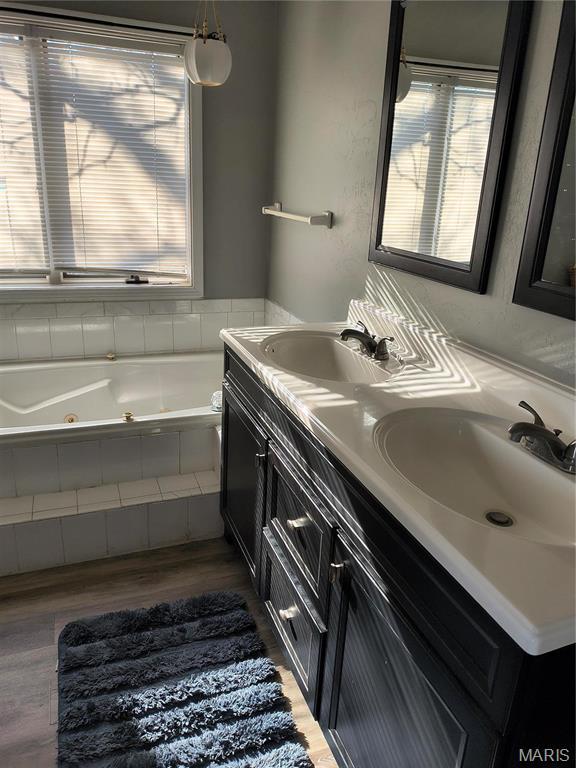 10740 Wilmena Ln, Rolla, MO 65401 - full bathroom with wood finished floors, a jetted tub, and double vanity