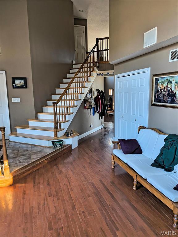 10740 Wilmena Ln, Rolla, MO 65401 - staircase featuring a high ceiling, wood finished floors, and baseboards