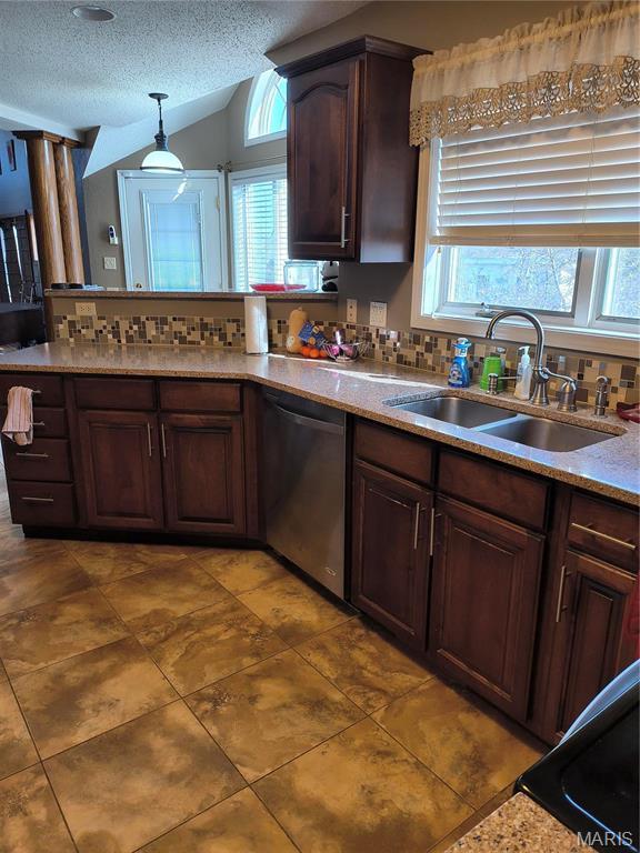 10740 Wilmena Ln, Rolla, MO 65401 - kitchen with stainless steel dishwasher, a sink, backsplash, a textured ceiling, and vaulted ceiling
