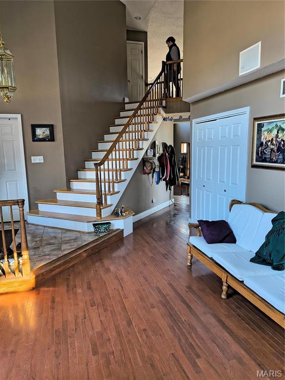 10740 Wilmena Ln, Rolla, MO 65401 - foyer featuring a towering ceiling, wood finished floors, stairway, and baseboards