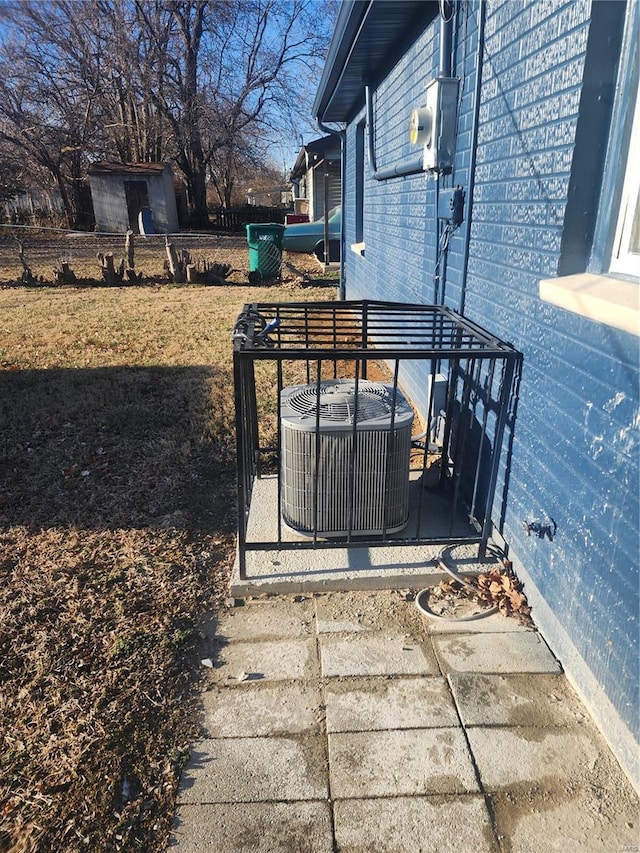 exterior view of cooling unit, electric meter, brick siding, and fence