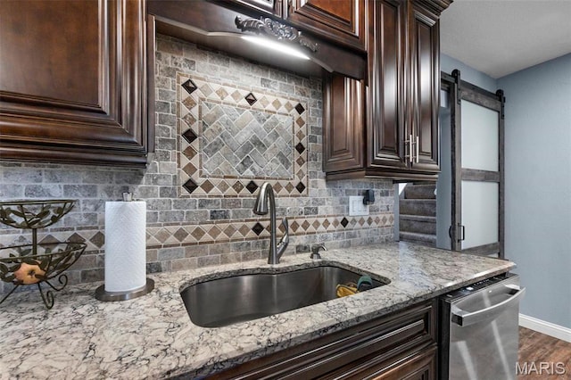 216 Sherrie Dr, Sikeston, MO 63801 - kitchen featuring stainless steel dishwasher, dark brown cabinetry, tasteful backsplash, and light stone countertops