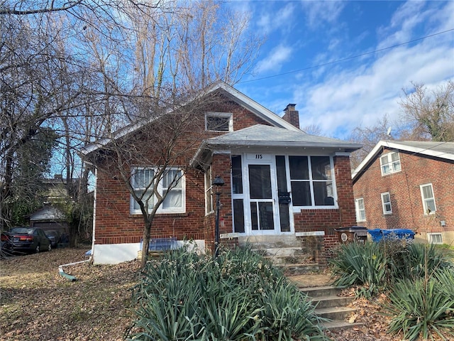 115 Lawrence Ave, Saint Louis, MO 63135 - view of front of house featuring a chimney, brick siding, and a sunroom