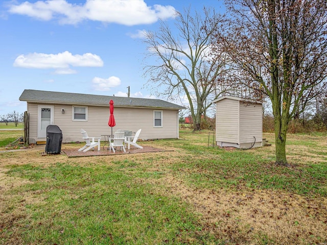 back of house featuring a yard, an outdoor structure, and a shed