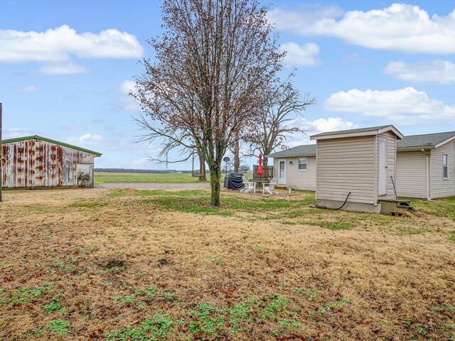 view of green lawn featuring an outbuilding
