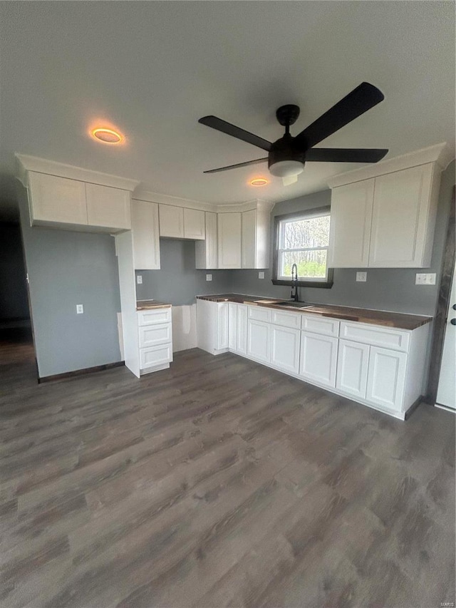 kitchen featuring a ceiling fan, white cabinets, and dark wood-style flooring