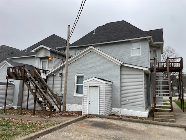 221 N 3rd St Unit 221, Louisiana, MO 63353 - rear view of property with stairway, a deck, brick siding, and a shingled roof