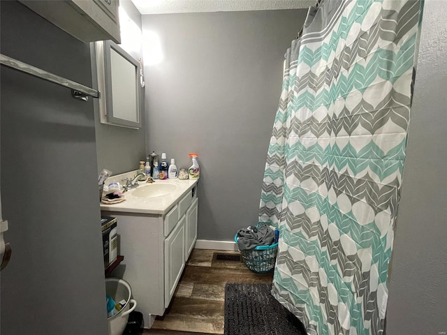221 N 3rd St Unit 221, Louisiana, MO 63353 - full bath with wood finished floors, vanity, a shower with shower curtain, and a textured ceiling