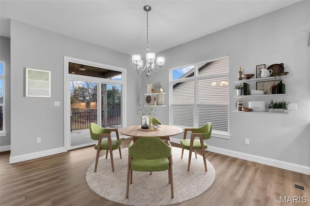 201 Keaton Woods Dr, Ofallon, MO 63368 - dining space featuring wood finished floors, baseboards, and a chandelier