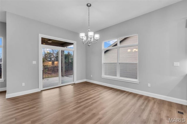 201 Keaton Woods Dr, Ofallon, MO 63368 - unfurnished dining area with wood finished floors, baseboards, and a chandelier