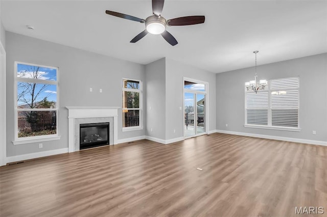 201 Keaton Woods Dr, Ofallon, MO 63368 - unfurnished living room featuring a chandelier, wood finished floors, and baseboards