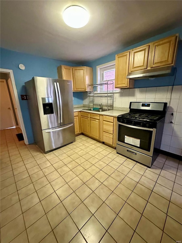 4025 Tholozan Ave, Saint Louis, MO 63116 - kitchen with stainless steel appliances, light countertops, under cabinet range hood, light tile patterned flooring, and backsplash