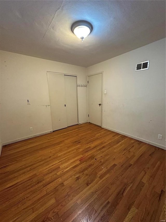 4828 Reavis Barracks Rd, Saint Louis, MO 63123 - unfurnished bedroom with wood finished floors, a closet, baseboards, and a textured ceiling