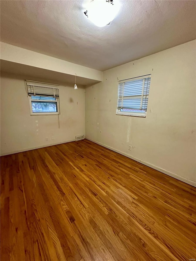 4828 Reavis Barracks Rd, Saint Louis, MO 63123 - spare room with wood finished floors, plenty of natural light, baseboards, and a textured ceiling
