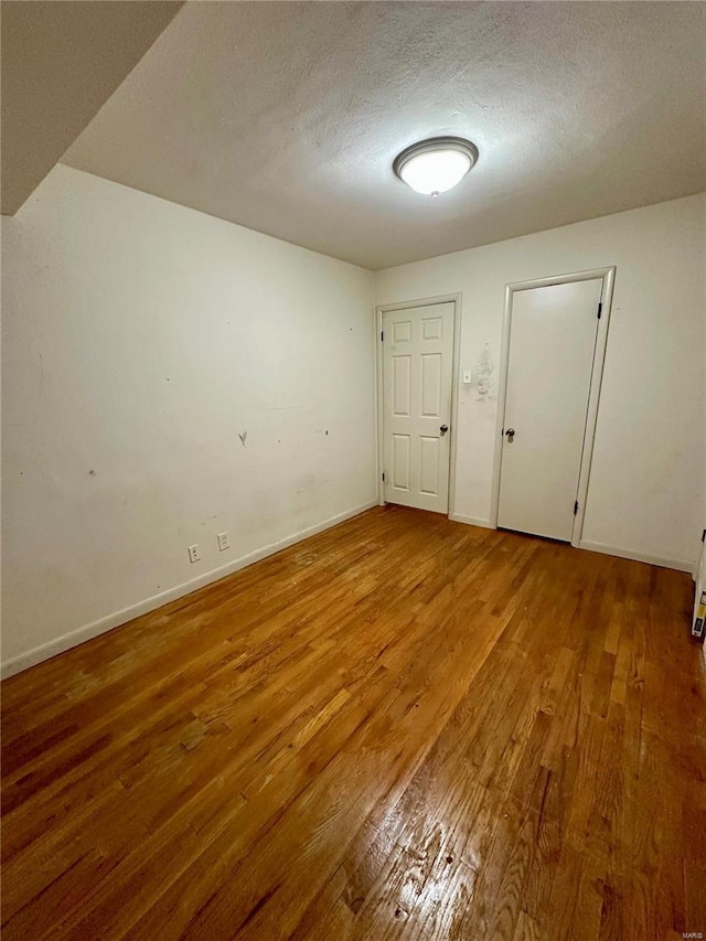 4828 Reavis Barracks Rd, Saint Louis, MO 63123 - spare room with wood finished floors, a textured ceiling, and baseboards